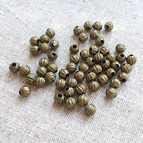 Bronze beads on a textured beige surface