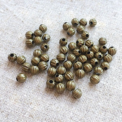 Bronze beads on a textured beige surface