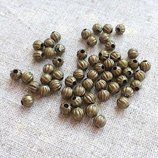 Bronze beads on a textured beige surface