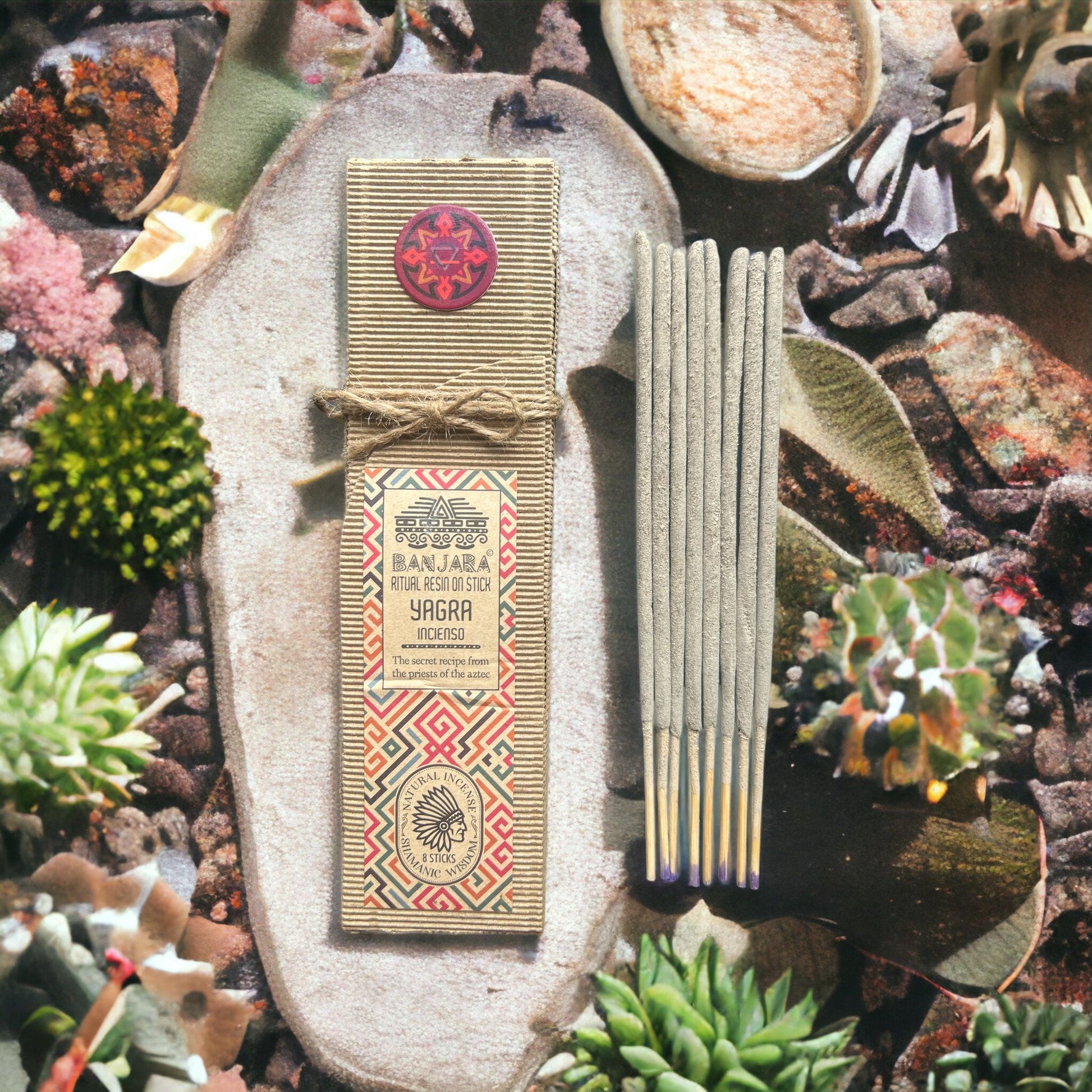 Incense sticks with packaging on a decorative stone surface with plants